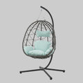 Luxury indoor and outdoor hanging egg chair with a black powder-coated steel stand and plush gray cushions on a sunlit patio.